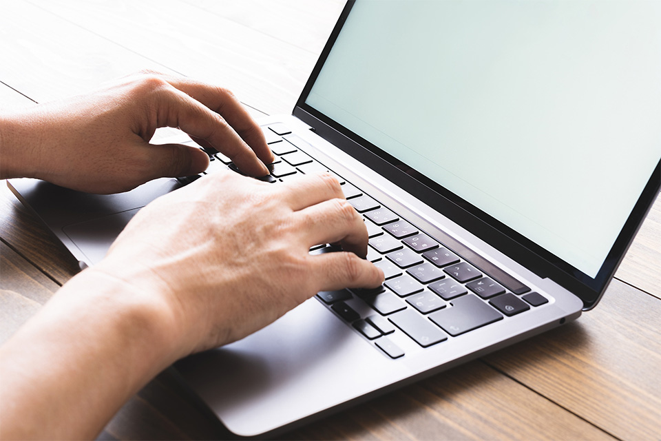 株式会社SORAQの担当者がノートパソコンでウェブマーケティング用のホームページ制作作業を行っている